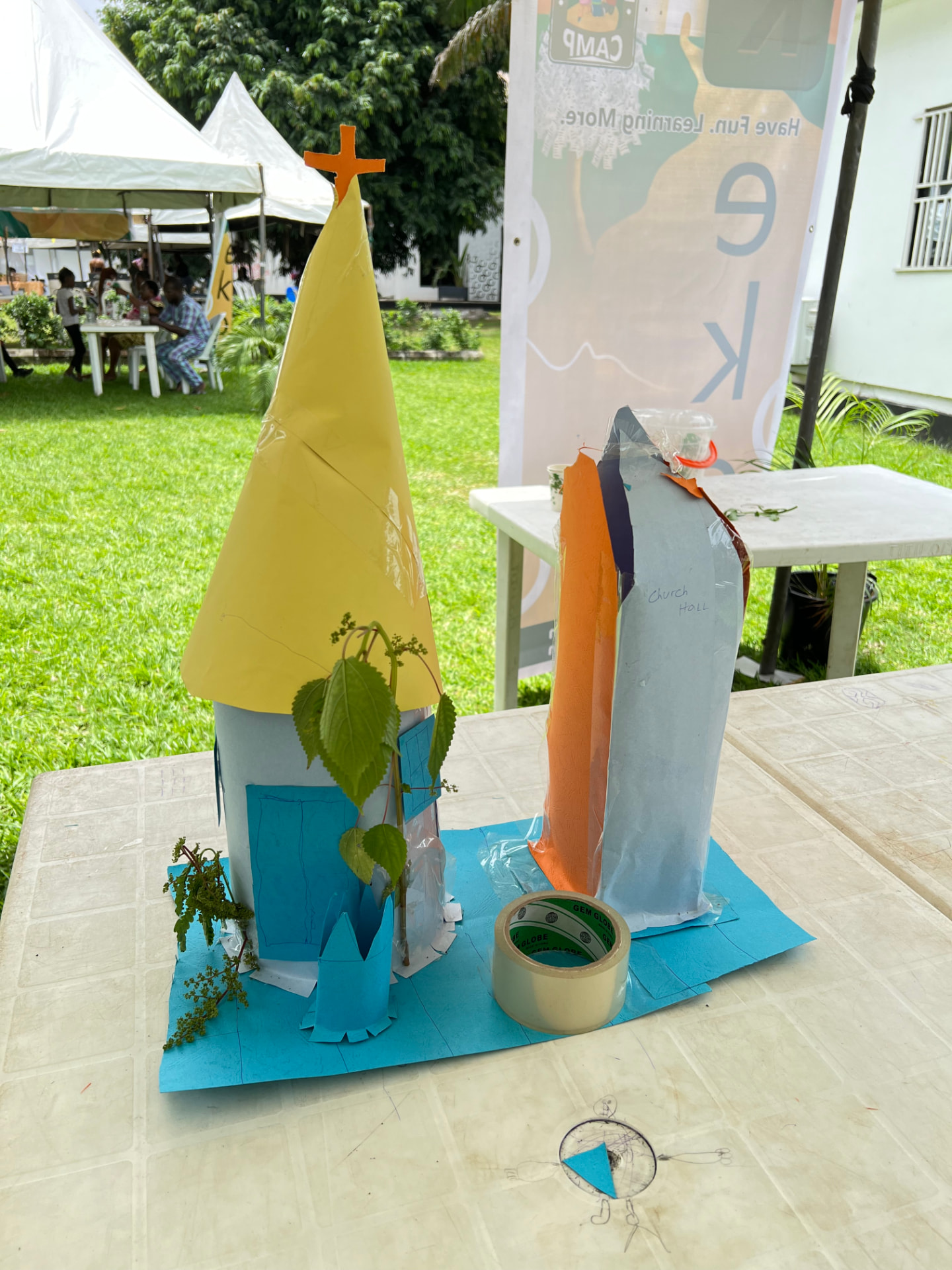 Child building a paper church model at Keko summer camp